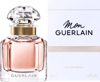 Mon Guerlain woda perfumowana. Butelka z różowym płynem, fasetowaną zakrętką, złotym paskiem i białe pudełko obok.
