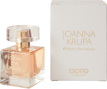 Perfumowana woda Joanna Krupa #follow the beauty: bursztynowy flakonik i białe pudełko obok, na jasnym tle.