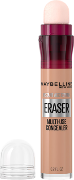 Brzoskwiniowy korektor Maybelline Instant Eraser z bordową szyjką i gąbkowym aplikatorem, obok przezroczysta zakrętka.