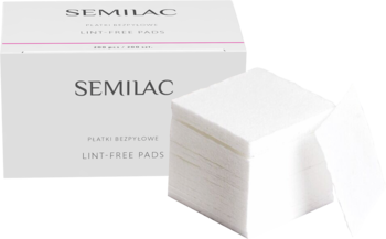 Białe opakowanie Semilac z bezpyłowymi płatkami poliestrowymi do paznokci i stos białych wacików. Widok z przodu.