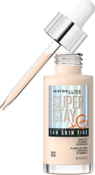Maybelline Super Stay 24H Skin Tint 03 z witaminą C, butelka z kroplomierzem nad beżowym fluidem.