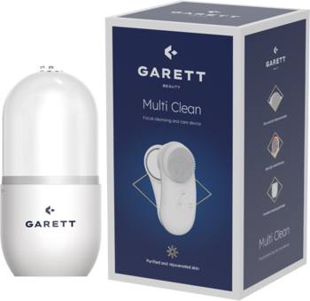 Garett Multi Clean, biała myjka soniczna do twarzy z przezroczystą nasadką, obok jej niebieskiego pudełka.