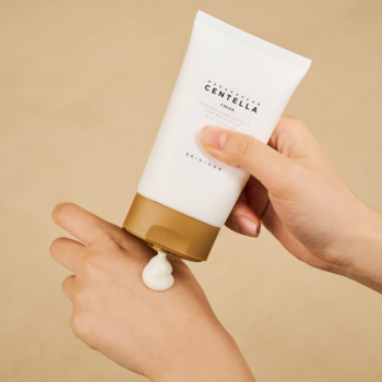 Madagascar Centella Cream, biała tuba z beżową nakrętką, z której wyciskany jest krem na dłoń.