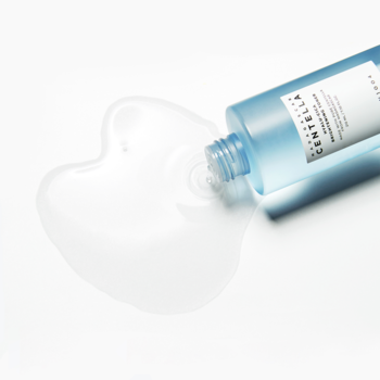 SKIN1004 Hyalu-Cica Brightening Toner w błękitnej butelce, wylewający bezbarwny płyn na białe tło.