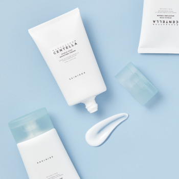 Biała tuba kremu SKIN1004 Centella Hyalu-Cica z wąkrotą, z kremem na jasnoniebieskim tle, widok z góry.