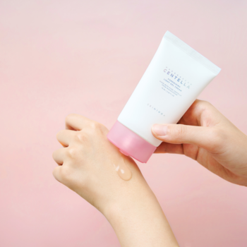 Krem do twarzy z Centellą Asiatica na pory, biała tubka z różową nakrętką, dłoń wyciska żel na rękę.