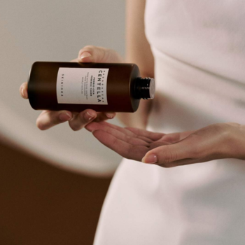 Nourishing facial toner Skin 1004 Madagascar Centella Probio-CICA w ciemnej butelce, dozowany na dłoń.