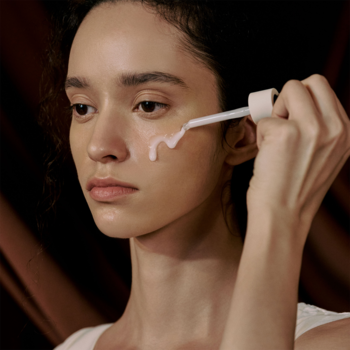 Kobieta aplikująca skoncentrowane serum Madagascar Centella Probio-CICA ampułką na wrażliwą skórę twarzy.