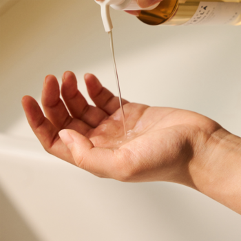 Skin1004 Madagascar Centella Light Cleansing Oil, klarowny olejek wylewany z butelki z pompką na otwartą dłoń.