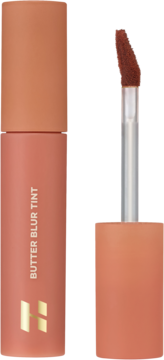 Holika Holika Butter Blur Tint 01 Salted, matowy tint do ust w rdzawym opakowaniu z aplikatorem obok.