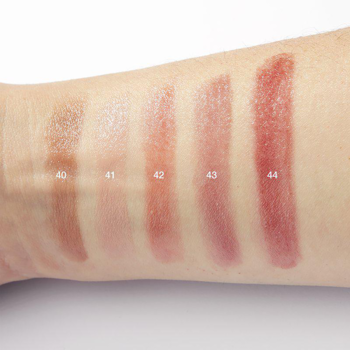 Pięć błyszczących próbek nawilżającego balsamu do ust IsaDora Glossy Balm na przedramieniu, widoczny odcień 41 Pink Silk.