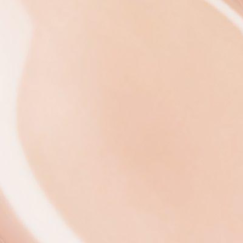 Zbliżenie na płynną konsystencję błyszczyka IsaDora Glossy Lip Treat 57 Cream Rose, delikatny róż, kremowy odcień.