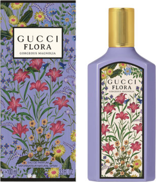 Fioletowa butelka perfum Gucci Flora Gorgeous Magnolia z kwiecistą etykietą i złotą nakrętką, obok pasujące pudełko.
