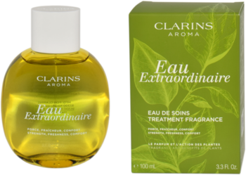 Pielęgnacyjny zapach Clarins Eau Extraordinaire. Obła butelka z żółtym płynem i zielone pudełko z liśćmi. Widok z przodu.