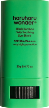 Zielony sztyft Haruharu Wonder Black Bamboo Sun Shield SPF 50+, widok z przodu z czarną obrotową podstawą.