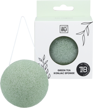 Okrągła, jasnozielona gąbka konjac Ilū do twarzy obok białego opakowania "Green Tea Konjac Sponge".