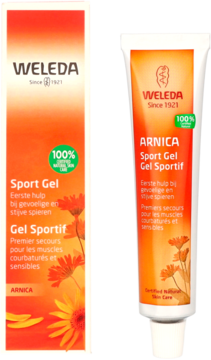 Weleda Arnica Sport Gel w pomarańczowo-żółtej tubie i pudełku z arniką, na jasnym tle, ułożone obok siebie.