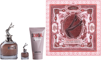 Zestaw perfum Scandal JPG: woda perfumowana z korkiem-nogami, miniatura i balsam do ciała, na różowym tle.