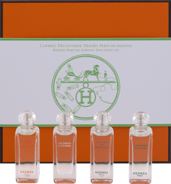 Zestaw Hermès Parfums-Jardins: cztery miniatury wód toaletowych Hermès 7,5ml, na tle pomarańczowego pudełka z logo.