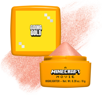 Kremowy rozświetlacz NYX Minecraft Movie Going Gold w pomarańczowych kompaktach, jeden otwarty z różowym produktem.