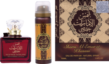 Zestaw AAZ Shams Al Emarat Khususi: czerwona woda perfumowana 100ml, złoty dezodorant, widok z przodu obok opakowania.