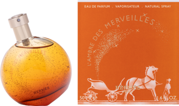 Hermes L'Ambre Des Merveilles: okrągła bursztynowa butelka i pomarańczowe pudełko z napisem i grafiką konia.