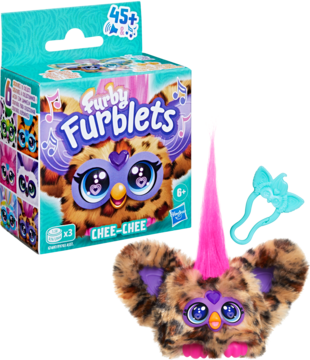Furby Furblets Chee-Chee w leopardzie futro, z różowym rogiem i niebieskim akcesorium, obok turkusowe pudełko.