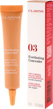Clarins Everlasting Concealer 03, brzoskwiniowa tubka obok białego pudełka. Widok z przodu, długotrwały, nawilżający.