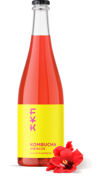 Forever Young Kombucha Hibiskus w szklanej butelce z różowo-czerwonym płynem, żółta etykieta. Obok kwiat hibiskusa, widok z przodu.