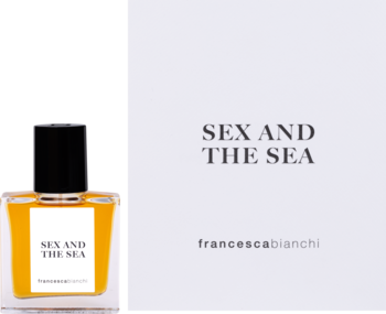 Perfumy Francesca Bianchi Sex And The Sea, bursztynowa butelka obok białego pudełka z nazwą produktu.