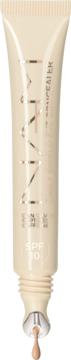 Beżowy korektor ILIA z filtrem SPF 10 w tubce, widok z przodu z wyciśniętą kroplą produktu.