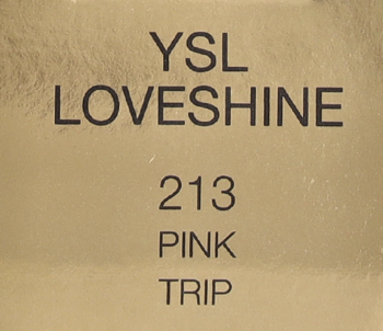 Złota, fakturowana etykieta YSL LOVESHINE z czarnym tekstem: 213 PINK TRIP. Opakowanie pomadki do ust.